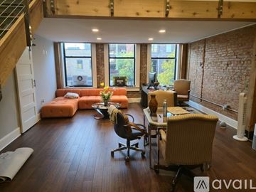 Kalamazoo apartment for rent - A room with wooden flooring and a staircase in the background.