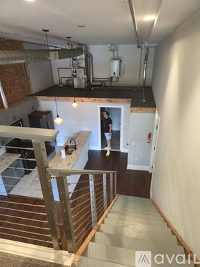Kalamazoo apartment for rent - A man is standing in a doorway in a room with a staircase.