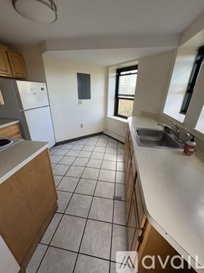 Boston apartment for rent - A kitchen with white appliances and wooden cabinets.
