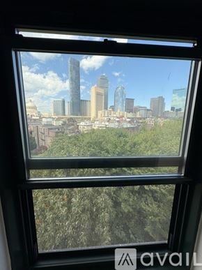 Boston apartment for rent - A window with a view of a city skyline.