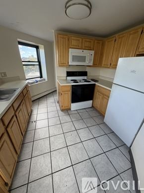 Boston apartment for rent - A kitchen with wooden cabinets and a white fridge.