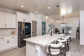 Lake Havasu City house for rent - A modern kitchen with a large island and bar stools.