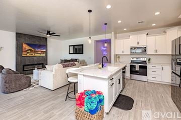 Lake Havasu City house for rent - A modern kitchen and living room with a fireplace and a painting on the wall.