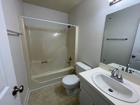 Wilson apartment for rent - A white bathroom with a toilet, sink, and shower.