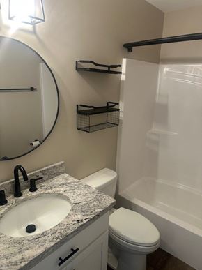 Madisonville house for rent - A bathroom with a sink, toilet, and bathtub.