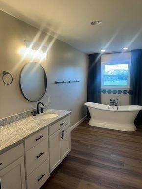 Madisonville house for rent - A bathroom with a white tub and a round mirror on the wall.