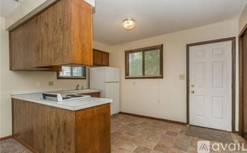 Des Moines house for rent - A kitchen with wooden cabinets and a white refrigerator.