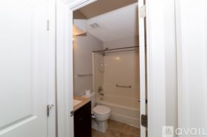 Des Moines house for rent - A bathroom with a toilet, sink, and bathtub.