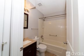 Des Moines house for rent - A bathroom with a toilet, sink, and bathtub.