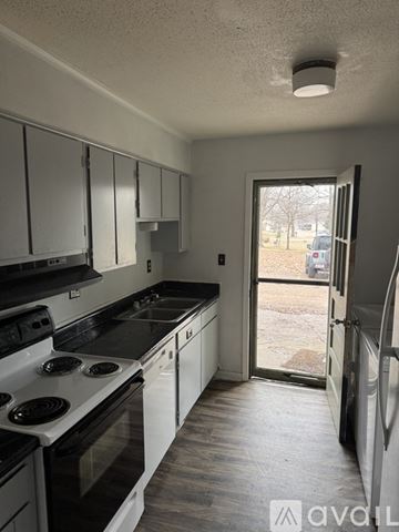 Ripley apartment for rent - A kitchen with white cabinets and black appliances.