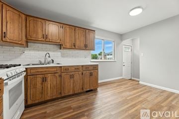 Macomb County house for rent - A kitchen with wooden cabinets and a white stove top oven.
