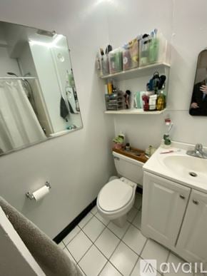Boston apartment for rent - A bathroom with a toilet, sink, and mirror.