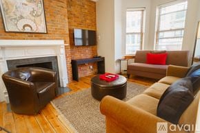 Boston apartment for rent - A living room with a fireplace and a brown couch.