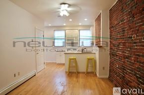 Boston apartment for rent - A kitchen with a brick wall and wooden floors.