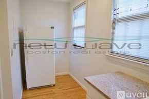 Boston apartment for rent - A white refrigerator in a room with a window and wooden floors.