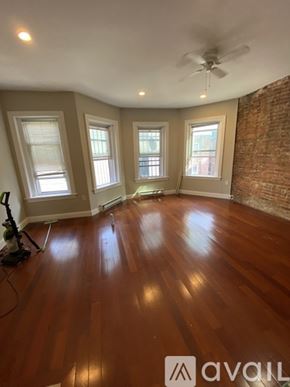 Boston apartment for rent - A room with wooden floors and a ceiling fan.