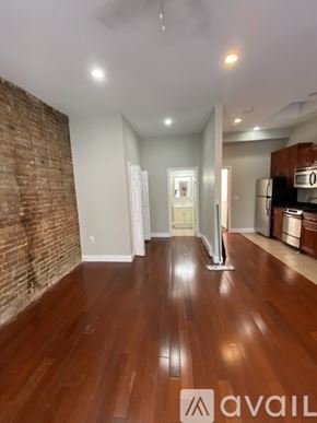 Boston apartment for rent - A room with wooden floors and a brick wall.