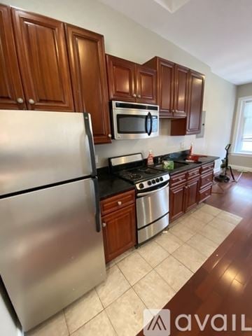 Boston apartment for rent - A kitchen with wooden cabinets and a stainless steel refrigerator.
