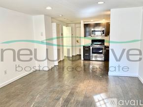 Boston apartment for rent - A spacious living room with a kitchen in the background and a sign that says "new boston residential".