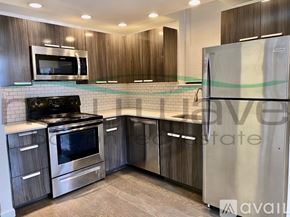 Boston apartment for rent - A kitchen with a stainless steel refrigerator, microwave, oven, and cabinets.