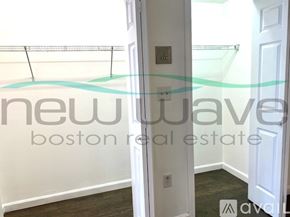 Boston apartment for rent - A hallway with a door and a wall-mounted light switch.