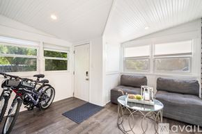 Gulfport house for rent - A modern dining room with a glass table and white chairs.
