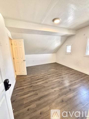 Los Angeles house for rent - A room with wooden flooring and a door on the left.