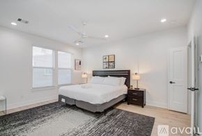 Houston townhouse for rent - A bedroom with a large bed, a ceiling fan, and a rug on the floor.