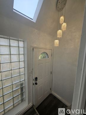 Pittsburgh house for rent - A white door is in a hallway with a skylight above it.