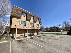 Englewood apartment for rent - A parking lot in front of a brick building with a motorcycle parked.