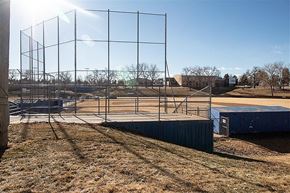 Englewood apartment for rent - A tennis court with a fence and a building in the background.
