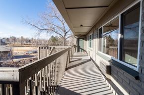 Englewood apartment for rent - A wooden deck with a railing and a view of a playground.