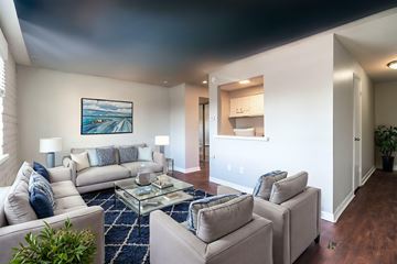 Englewood apartment for rent - A living room with a grey couch, a coffee table and a painting on the wall.