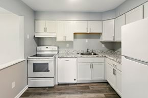 Merrillville apartment for rent - A room with a white wall and a wooden floor.