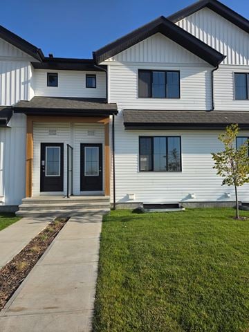 Calgary apartment for rent - A white house with a black door and windows.