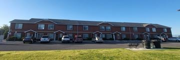 Powell apartment for rent - A red brick building with a parking lot in front.