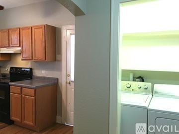 San Antonio house for rent - A kitchen with wooden cabinets and a washing machine.
