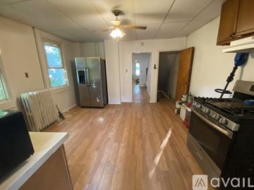 Kingston apartment for rent - A kitchen with a stove, refrigerator, and a fan on the ceiling.