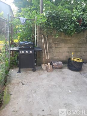 Philadelphia townhouse for rent - A black grill is on a patio next to a wall.