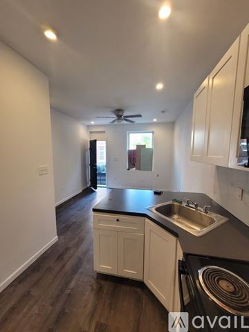 Philadelphia townhouse for rent - A kitchen with white cabinets and a black countertop.