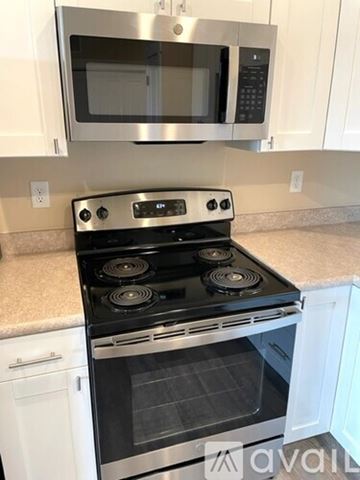 Missoula apartment for rent - A modern kitchen with a stove top oven and microwave above it.