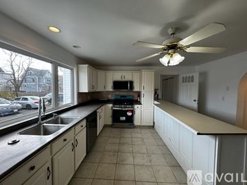 Malden apartment for rent - A kitchen with a fan and a black counter top.
