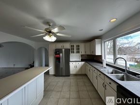 Malden apartment for rent - A kitchen with a fan on the ceiling and a refrigerator in the middle.