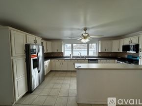 Malden apartment for rent - A kitchen with white cabinets and a refrigerator.