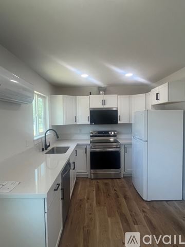 Redding house for rent - A kitchen with white cabinets and a wooden floor.