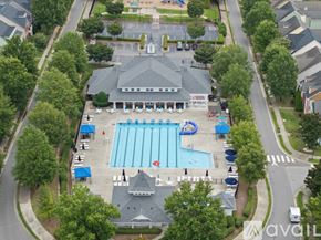 Morrisville house for rent - An aerial view of a swimming pool surrounded by trees and a building.