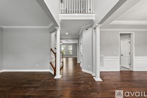 Morrisville house for rent - A spacious room with wooden floors and white walls.