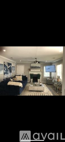 Atlanta house for rent - A living room with a blue couch and a television.