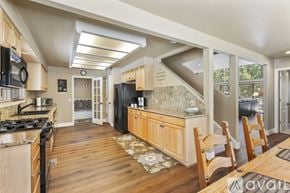 Breckenridge house for rent - A kitchen with wooden cabinets and a black refrigerator.