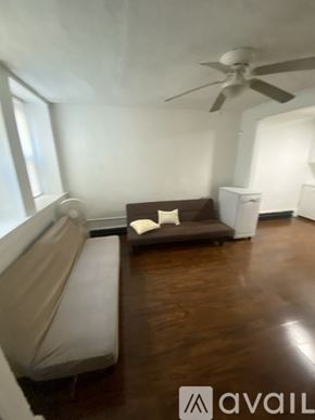 Boston apartment for rent - A living room with a couch, a fan, and a cabinet.
